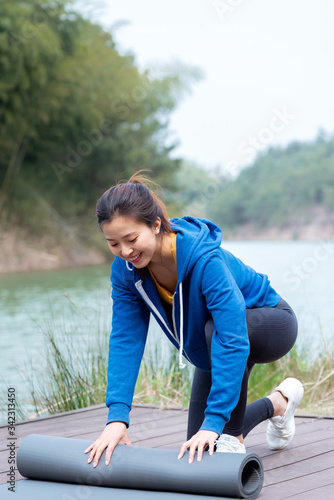 A young Asian woman practicing yoga in the outdoors © 出 小
