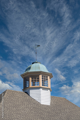 A classic cupola under clear blue skies topped by a weather vane © dbvirago