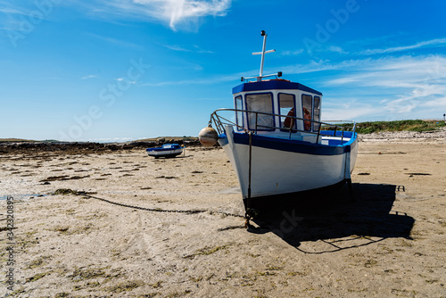 Stranded ships at low tide in the beach. Kervenni in Pointe du Castel Ach. Sunny day of summer photo