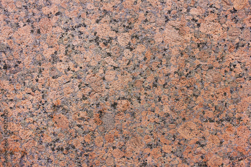 Granite stone wall texture pattern of natural mineral rock background. Granite massive hard rock structure background. Empty rough stone material, dark red granite surface 