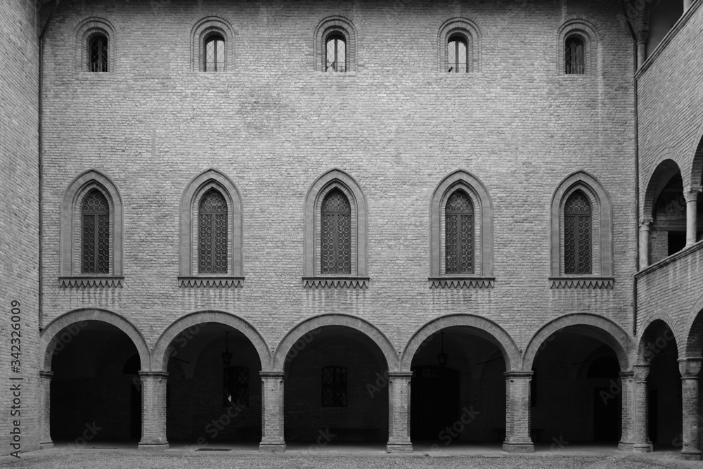 Obraz premium Architettura di un palazzo storico di Fontanellato, finestre ed arco di mattoni all'interno del castello, Parma