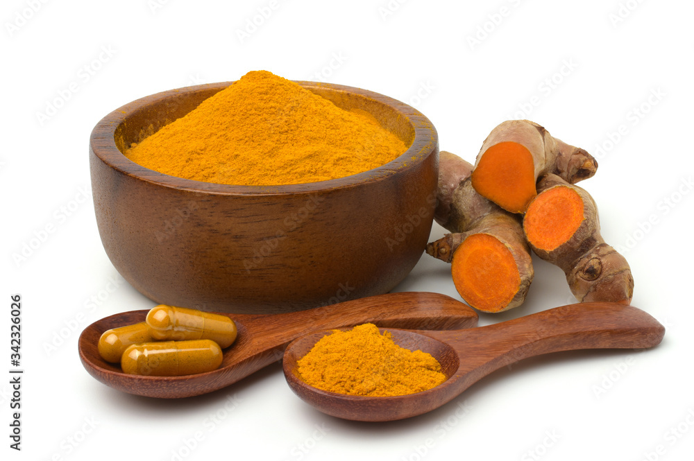 Turmeric (curcumin) powder in wooden bowl ,capsules and fresh turmeric rhizome isolated on a white background. Turmeric (curcumin) powder in wooden bowl ,capsules and fresh turmeric rhizome isolated on a white background.