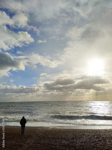 man beach sun clouds