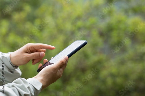 Hands using mobile phone in spring nature