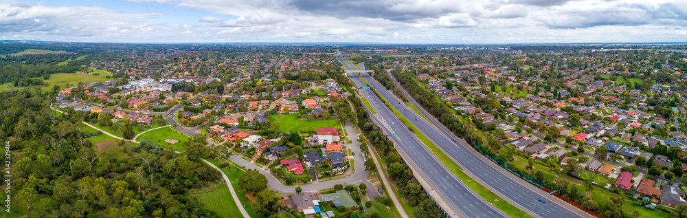 Fototapeta premium Eastlink highway passing through residential areas in Melbourne, Australia - aerial panorama