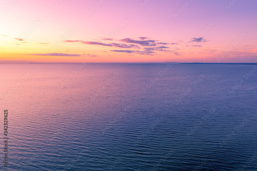 Vivid magenta orange sunset over water - aerial view with copy space