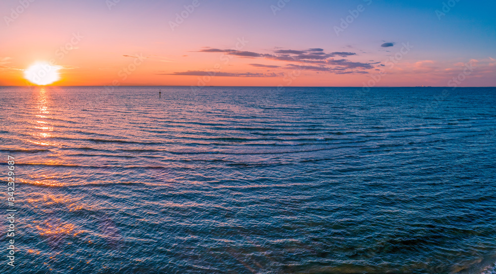Aerial panorama of sun setting over sea