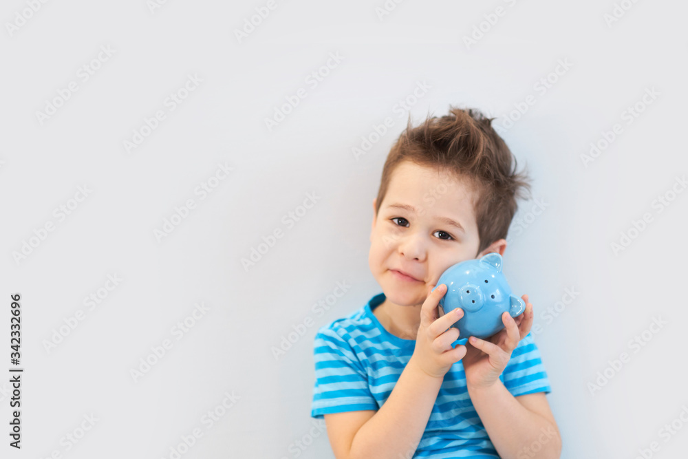 little asian boy holds a piggy bank in his hands. money saving concept