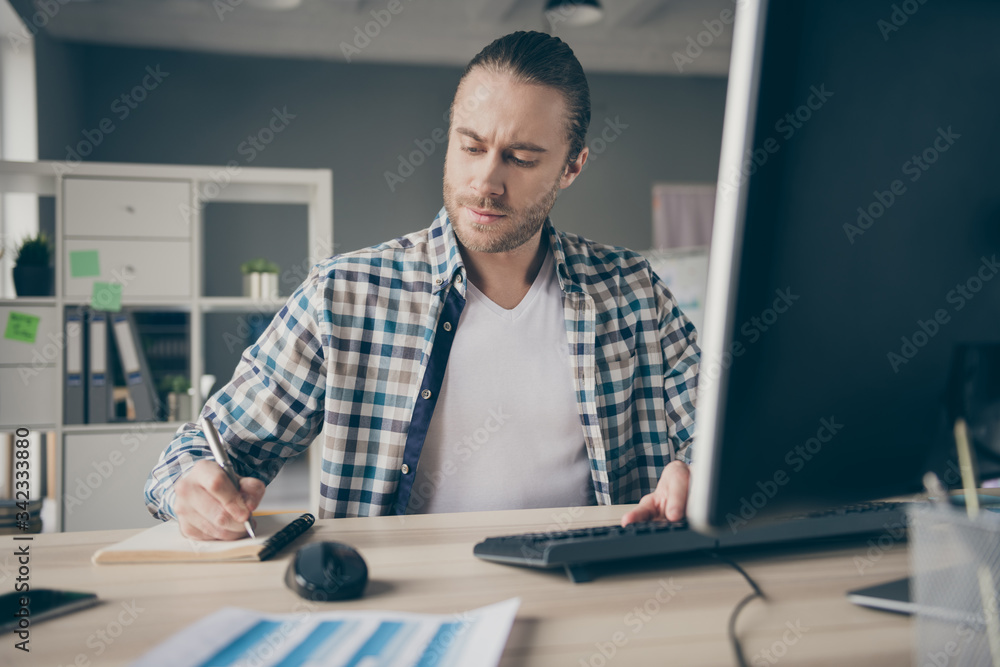 Photo of business administrator guy computer monitor table writing notes watch online webinar preparing important career promotion meeting wear casual shirt sit modern office indoors Photo of business administrator guy computer monitor table writing notes watch online webinar preparing important career promotion meeting wear casual shirt sit modern office indoors