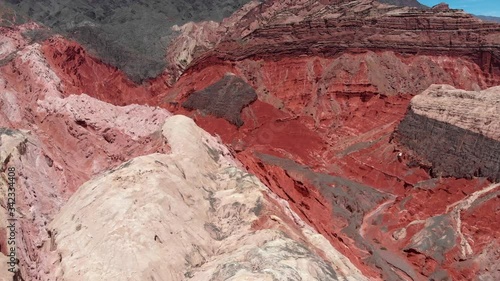 Flying by red mountains near Salta, Argentina. Aerial shot, 4K