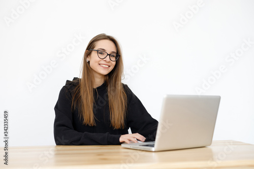 Young girl woman at the table, distance learning for students. Freelancer, distant work, work at home, online education