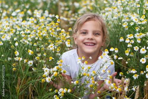 A little girl laughs in a field of daisies