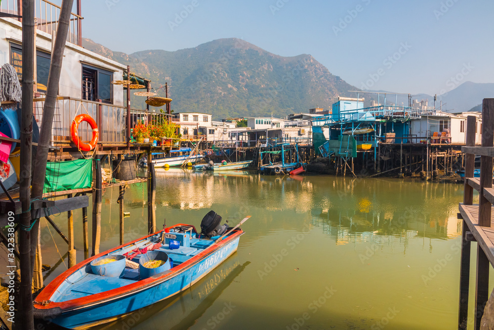 House on wooden stilts, Tai O, Lantau island, Hong Kong, China. Beautiful sunny outdoor shot of the fishing village. Boat tours available. Mountains in the background. 