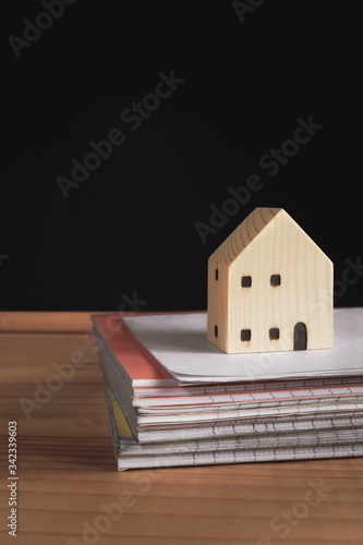 house model on a notebook pile with a blackboard background. distant studying class preparation for homeschool education.staying and learning from home during school shutdown because of covid-19.