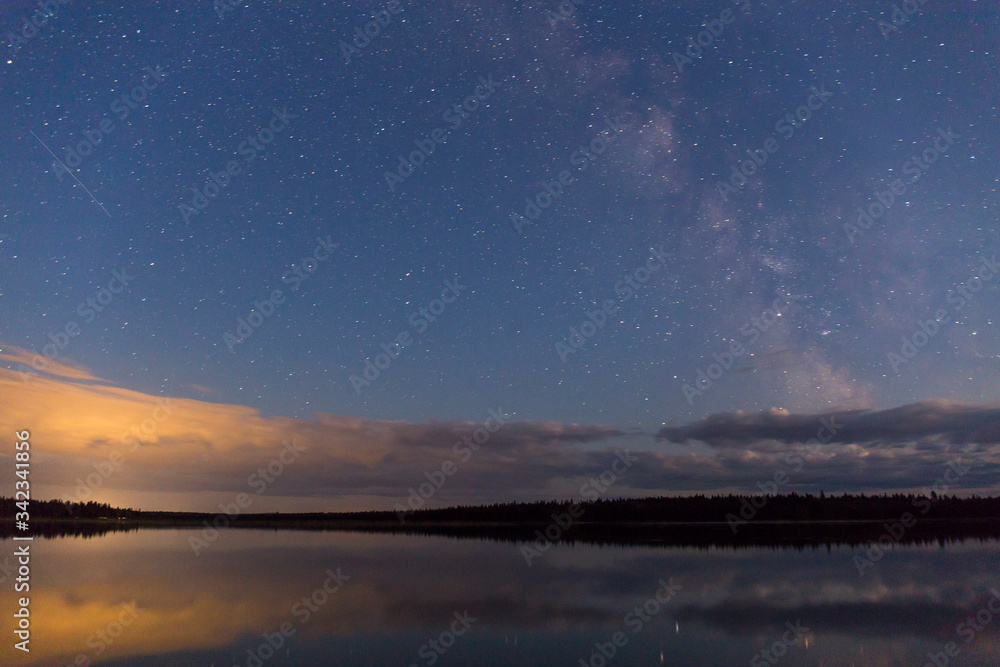 slow shutter, night on the lake, millions of stars in the blue sky reflected in the water, as well as the milky way slow shutter, night on the lake, millions of stars in the blue sky reflected in the water, as well as the milky way
