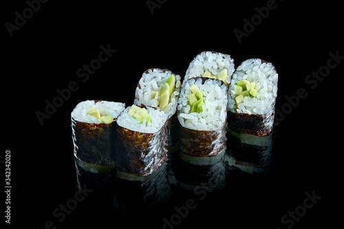 Traditional japanese maki sushi rolls with avocado on a black background with reflection. Photo for the menu. Close up