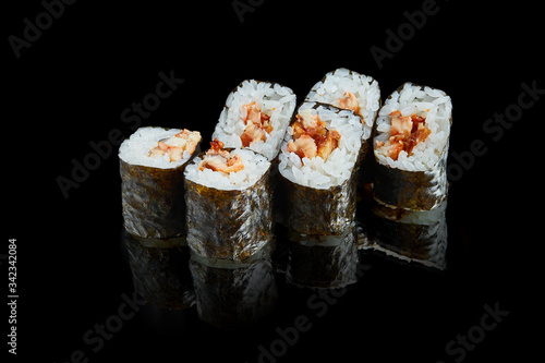 Traditional japanese maki sushi rolls with eel on a black background with reflection. Photo for the menu. Close up