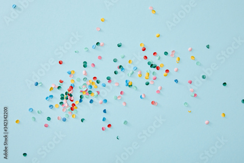 Top view of colorful confetti scattered on blue background