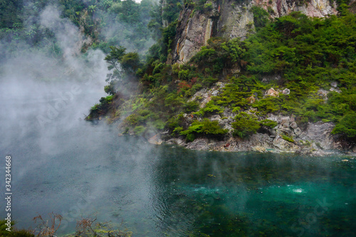 WAIMANGU VOLCANIC VALLEY, NEW ZEALAND - MARCH 03, 2020: Frying pan lake with a mist rising from the trees and the rocks around