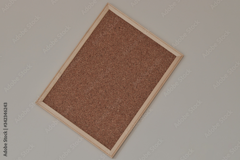 Fototapeta premium Cork board hanging on the wall with wooden frame.