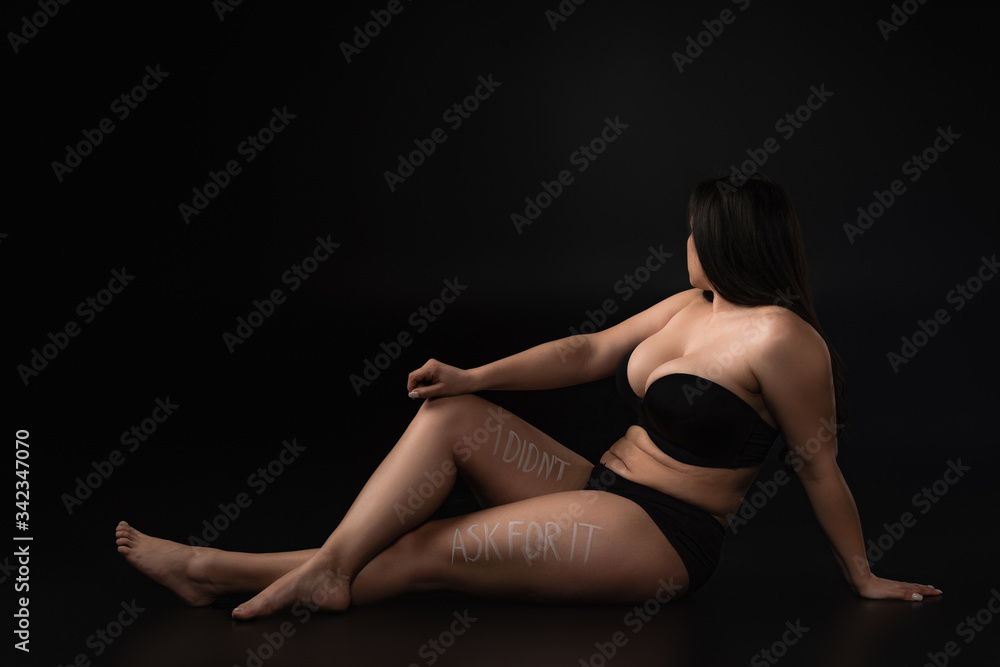 Full length plus size model in underwear with lettering  I Did not Ask For It on body on black background