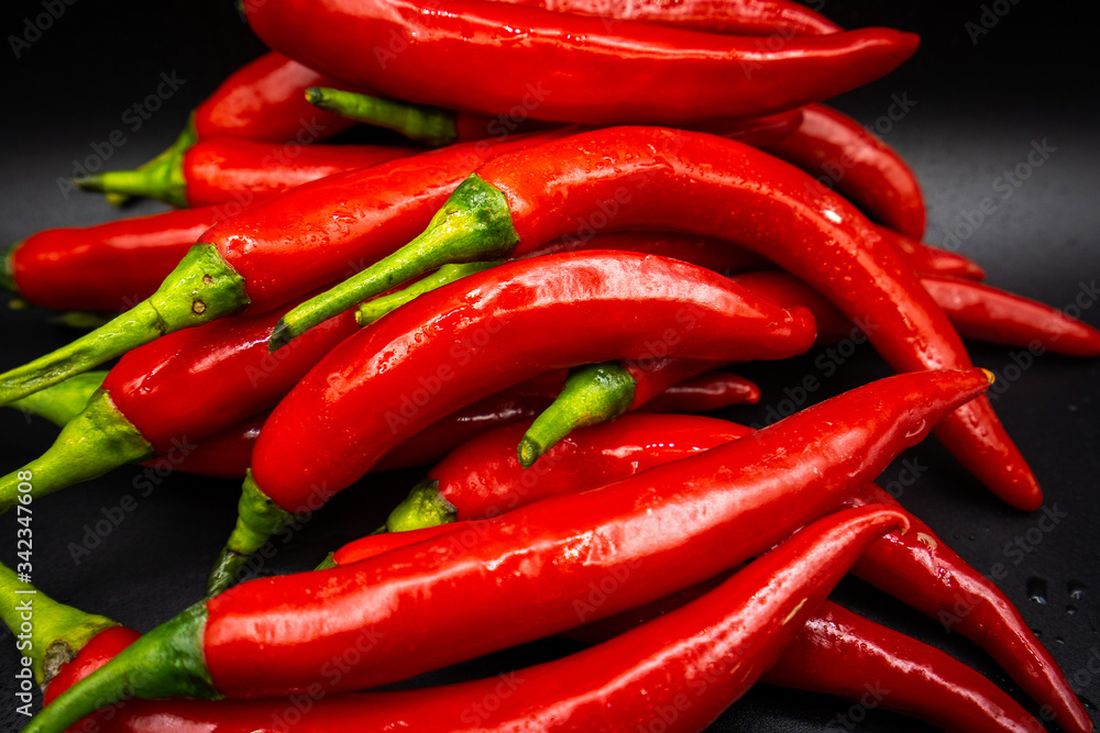 Many hot peppers on a black background