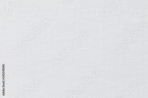 White Textured background of linen fabric in the morning light   White linen and cotton tablecloth. Photo taken from above with a natural morning light  coming from an out-of-frame window.