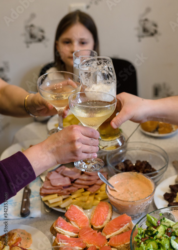 Friends and family people hands toasting white wine at the festive table