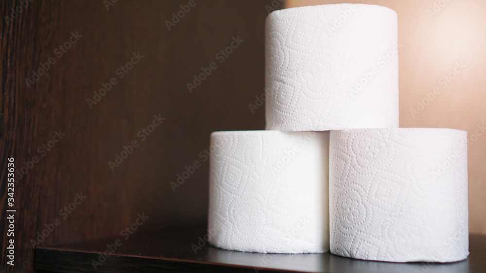 Fototapeta premium Toilet paper is consider a must item during crisis. Tissue rolls on dark background for copyspace