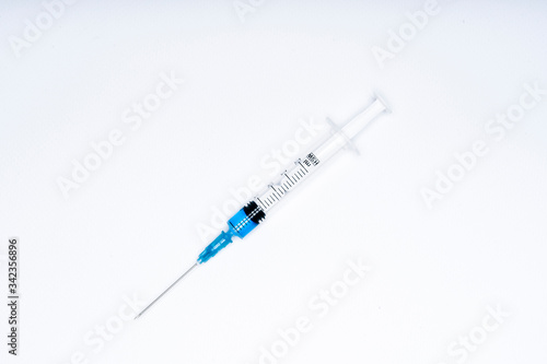 Isolated syringe with blue liquid on white background