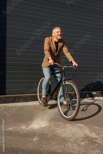 sunlight on handsome businessman riding bicycle outside