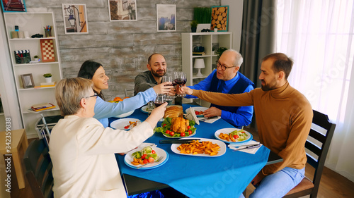 Top view of family clinking glasses with red wine