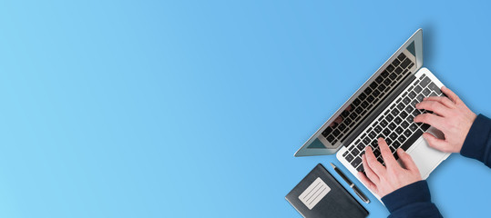 above view of person using laptop computer on blue background