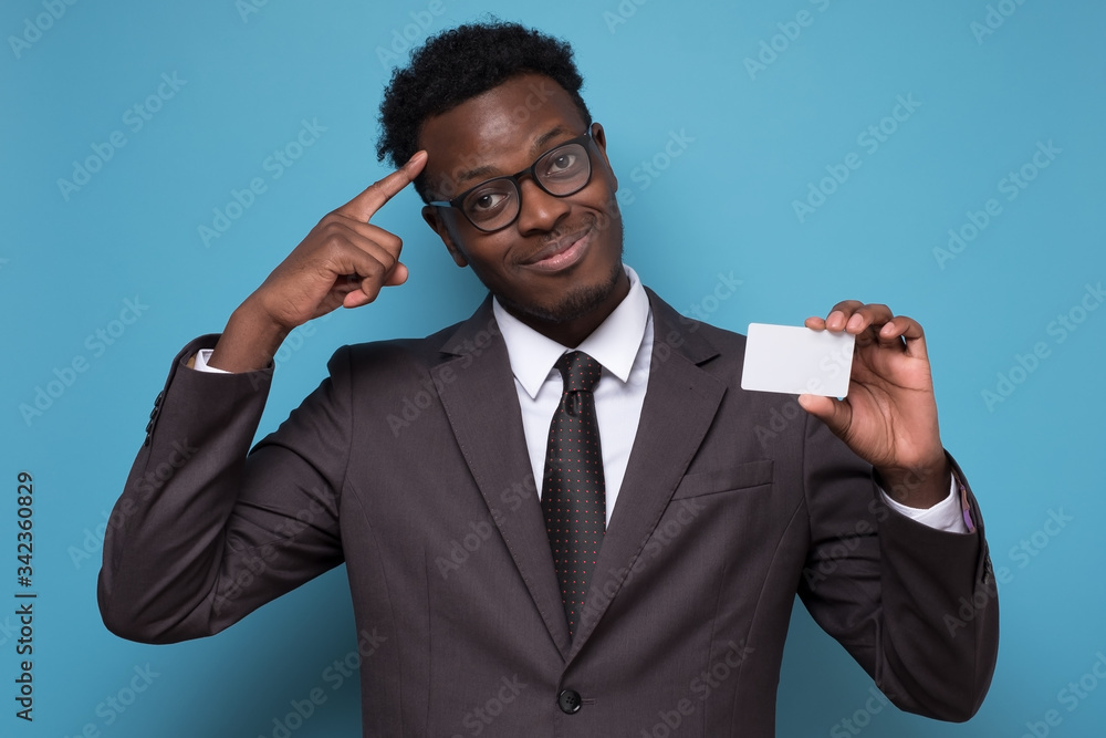 Young african american man in suit holding empty credit card generating idea. Young african american man in suit holding empty credit card generating idea.