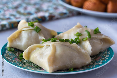 manti in a plate with a national pattern, Uzbek dishes, oriental cuisine