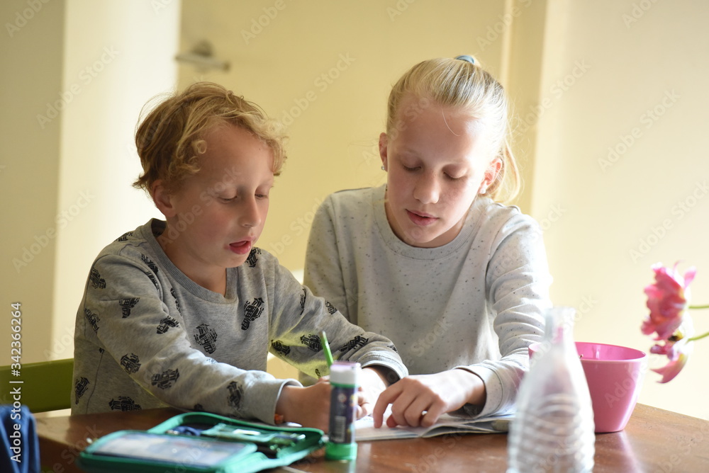 Mädchen hilft kleinem Bruder bei den Hausaufgaben Mädchen hilft kleinem Bruder bei den Hausaufgaben