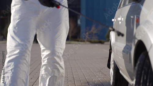 Wallpaper Mural Hazmat team worker disinfects car wheels with antibacterial sanitizer sprayer on coronavirus covid-19 quarantine. Man in gas mask, hazmat suit cleans parked car tires and body with pressure washer. Torontodigital.ca
