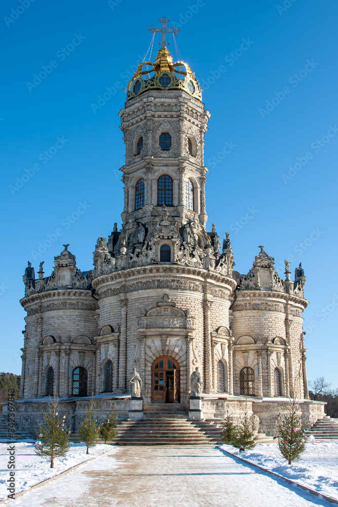 Fototapeta premium Beautiful church in winter stands on the snow against the sky