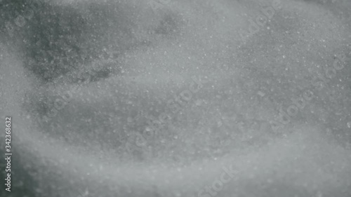 A 4K close up shot of sugar, sugar crystals rotating around. Side view shot of ingredients for a dessert.