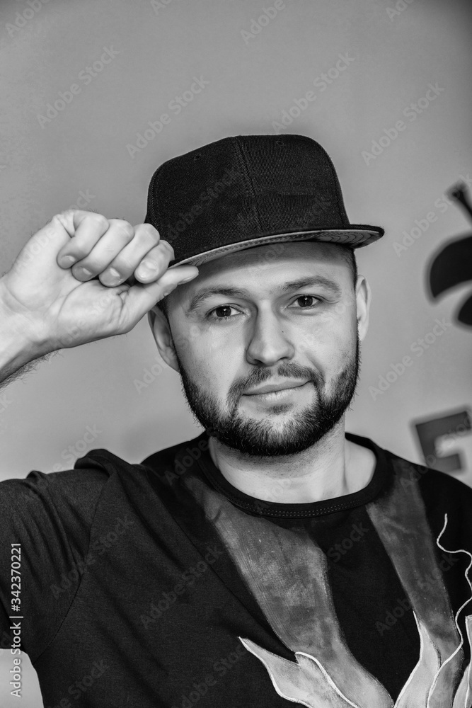 Hipster handsome male model with beard wearing black blank baseball cap with space for your logo Hipster handsome male model with beard wearing black blank baseball cap with space for your logo