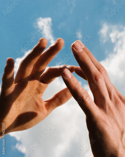 Close up of hands against cloudy sky