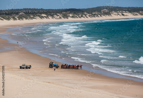 divers boat and car on the Indian Ocean long sandy beach Tofo Beach, Mozambique photo
