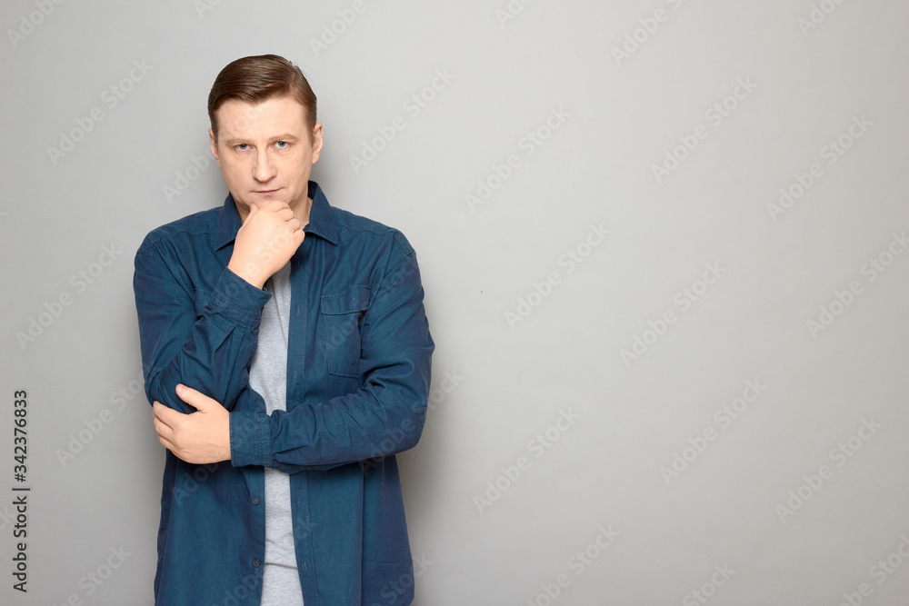 Portrait of serious focused thoughtful man touching chin with one hand Portrait of serious focused thoughtful man touching chin with one hand