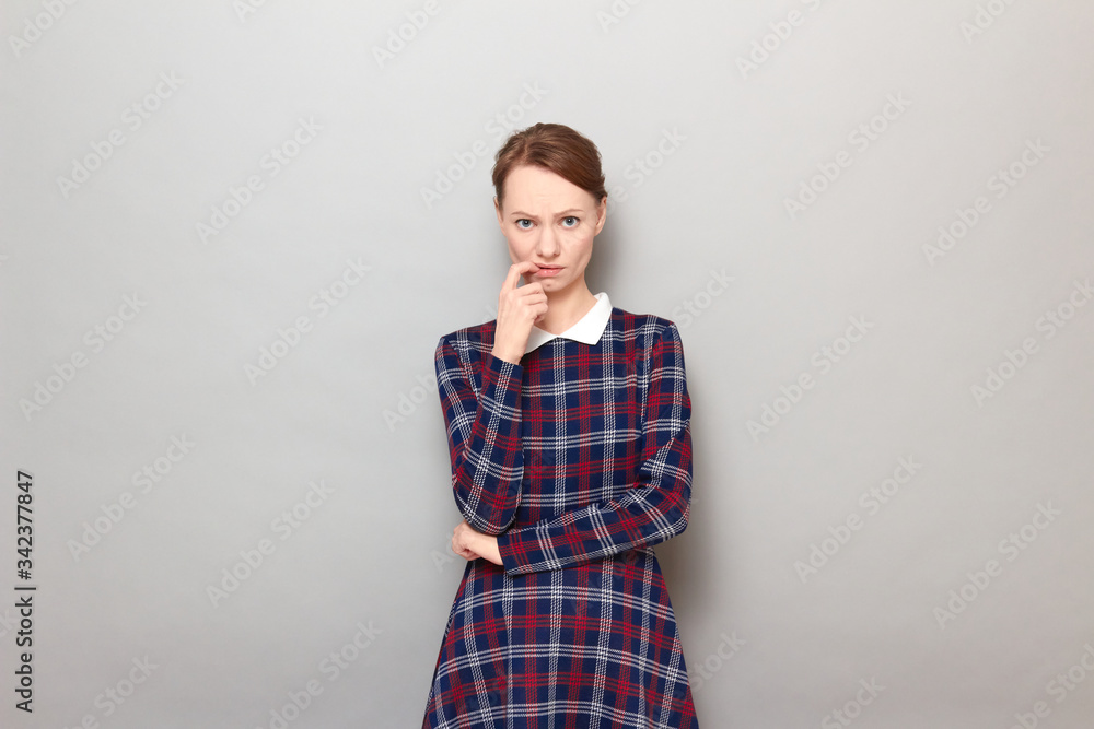 Portrait of sad disappointed young blond woman holding finger in mouth Portrait of sad disappointed young blond woman holding finger in mouth