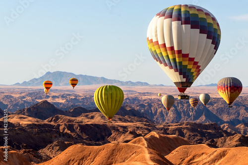 Colorful hot air balloons flying over the moon valley mountain. Africa. Namibia.