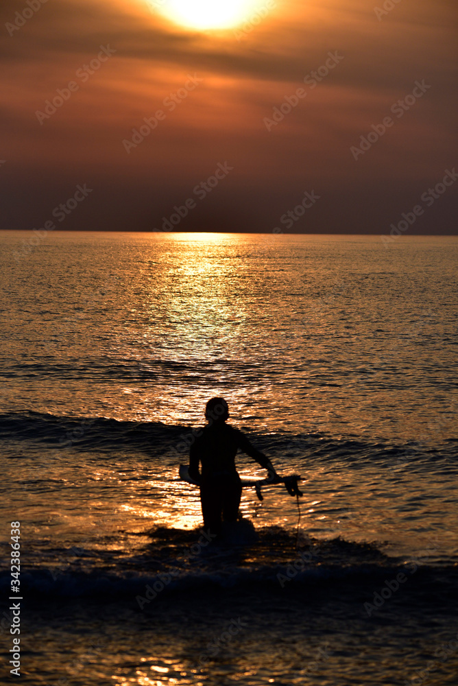 silhouette of a man with a surfboard
