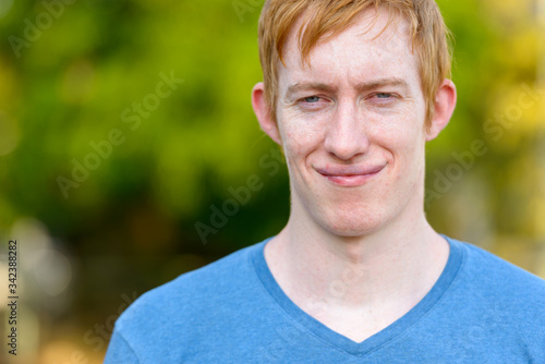 Face of man with red hair relaxing in the park