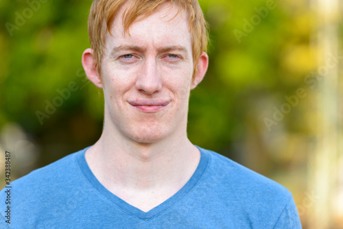 Face of man with red hair relaxing in the park