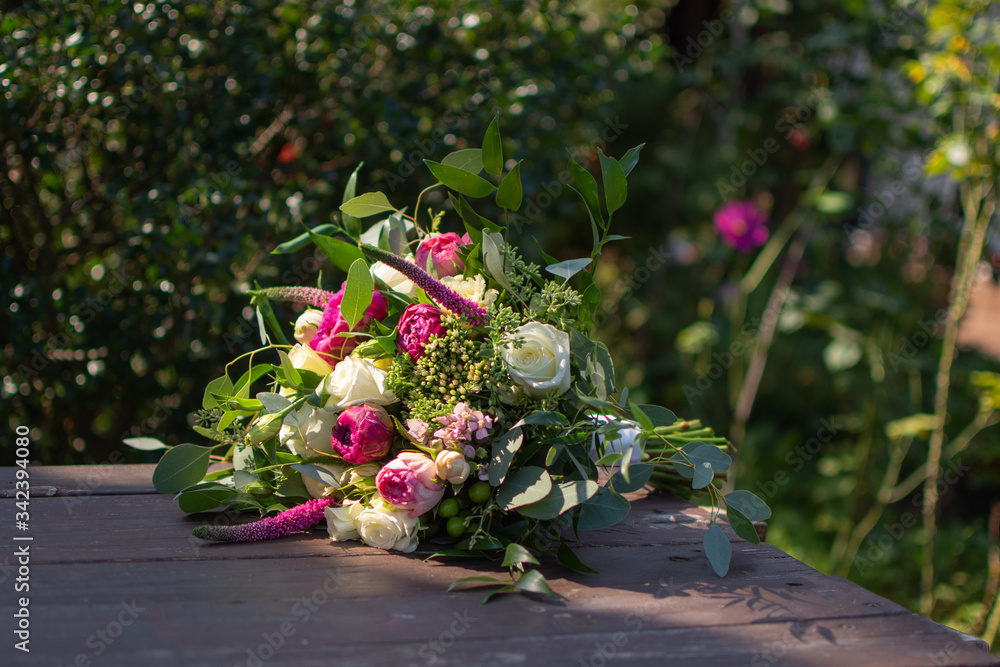 Colourful wedding bouquet with red roses, on wooden table outside