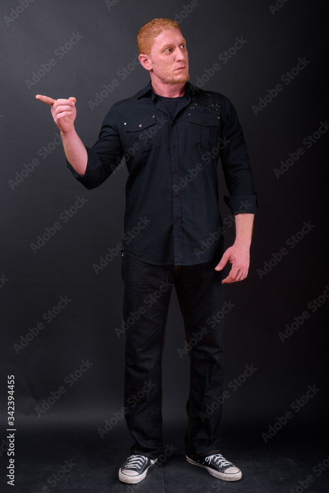 Full body shot of muscular man with orange hair pointing finger Full body shot of muscular man with orange hair pointing finger